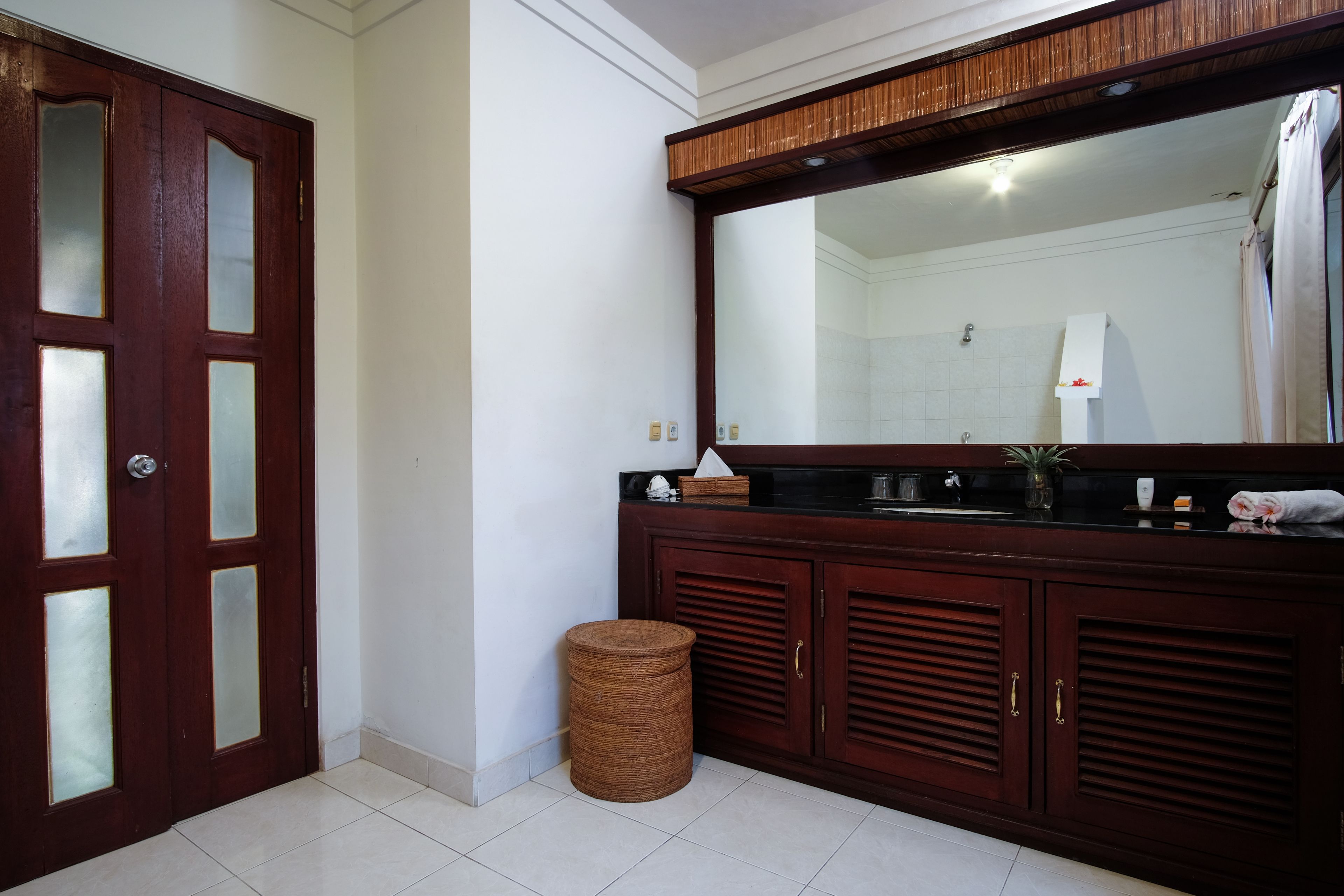 Une salle de bain avec un meuble-lavabo en bois, un miroir, un lavabo et des toilettes.