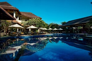 Una piscina al aire libre, sillones reclinables de piscina