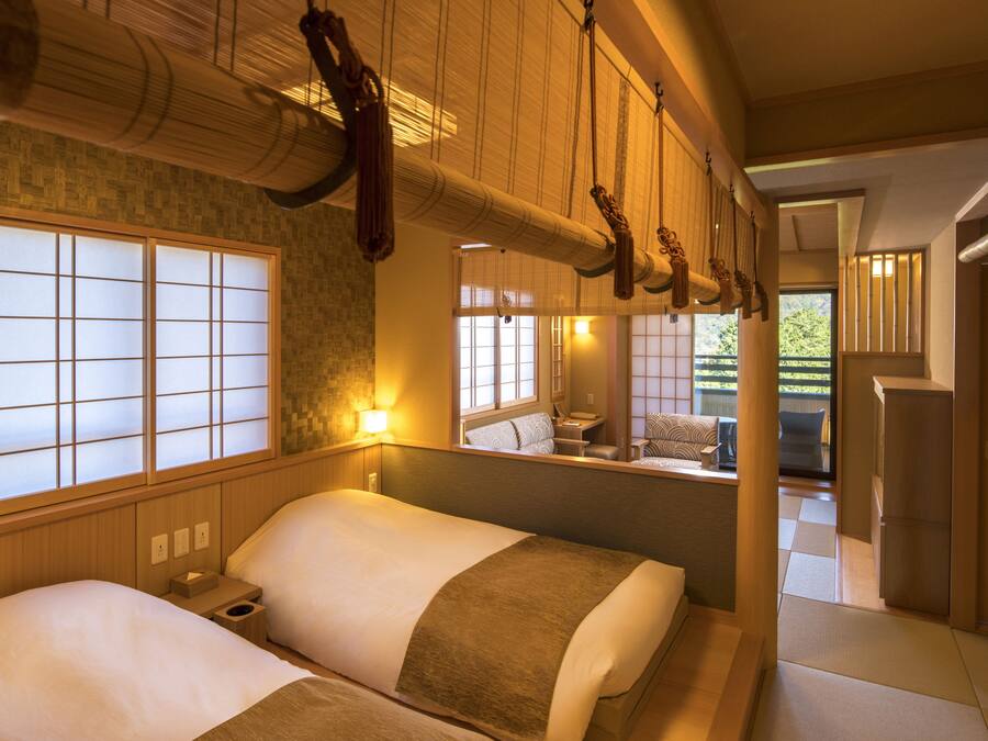 Una habitación tradicional japonesa con esteras de tatami, puertas correderas y vistas a un jardín.