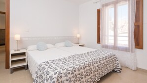A bedroom with a bed, bedside tables, and a window with curtains. - BIALI - Chalet with terrace in Buger. Free WiFi (Búger)