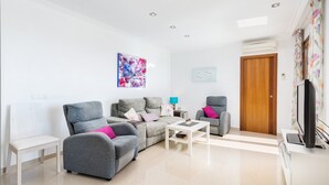 A modern living room with grey sofas, a white coffee table, and a wooden door. - BIALI - Chalet with terrace in Buger. Free WiFi (Búger)