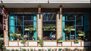 A building with large windows, potted plants, and a wooden facade. - Floral Hotel Zhangjiajie Mengqi Meiju (Zhangjiajie)