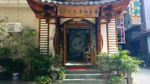 A traditional Chinese-style building with a tiled roof and wooden beams. - Floral Hotel Zhangjiajie Mengqi Meiju (Zhangjiajie)
