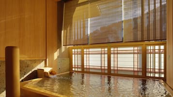 A traditional Japanese onsen with wooden interiors and a view through shoji screens.