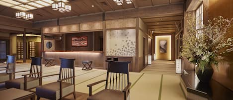 A traditional Japanese-style interior with tatami mat flooring, low wooden tables, and chairs.