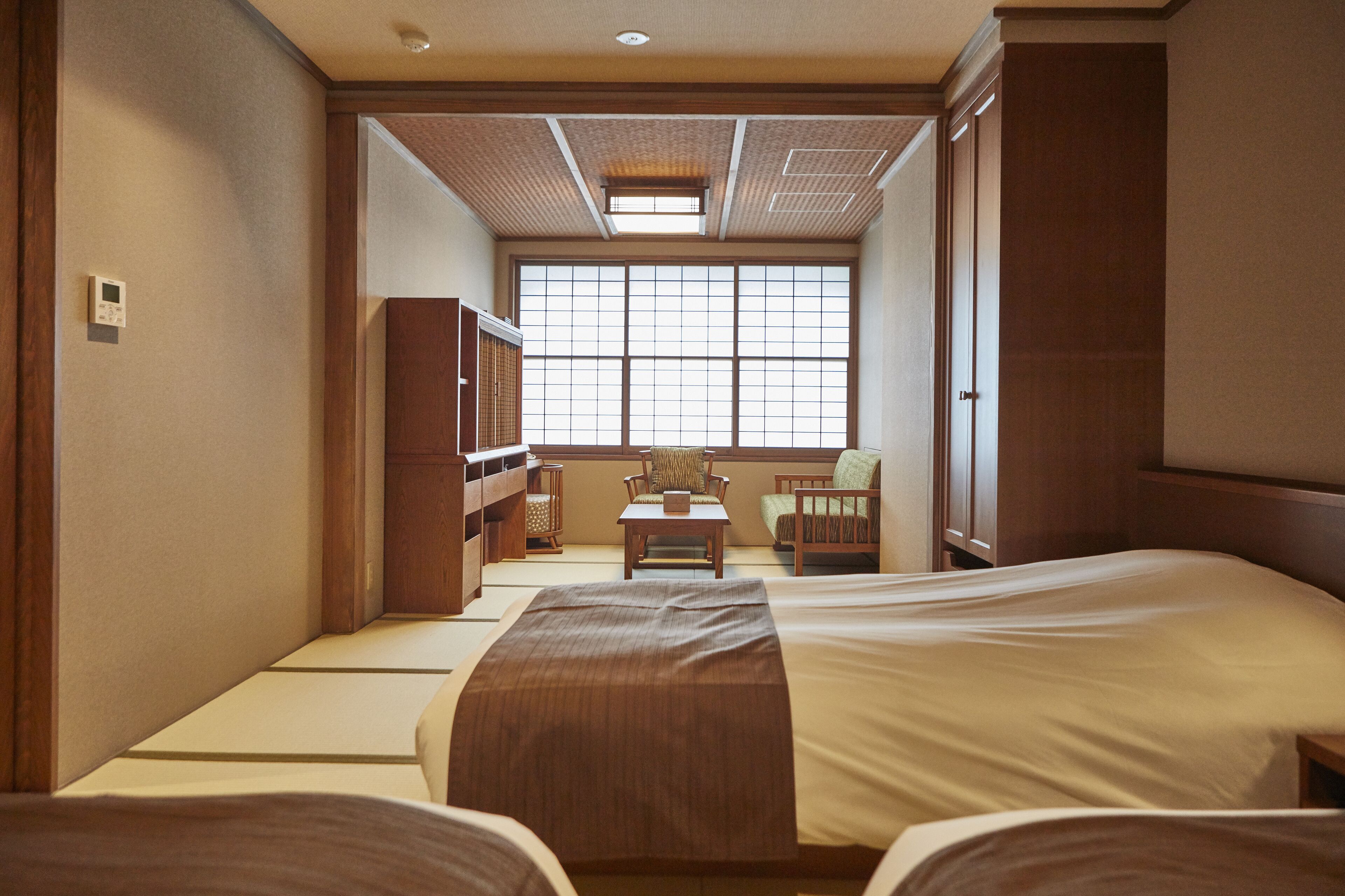 Una stanza tradizionale giapponese con pavimentazione in tatami, un tavolino e vista attraverso una grande finestra.