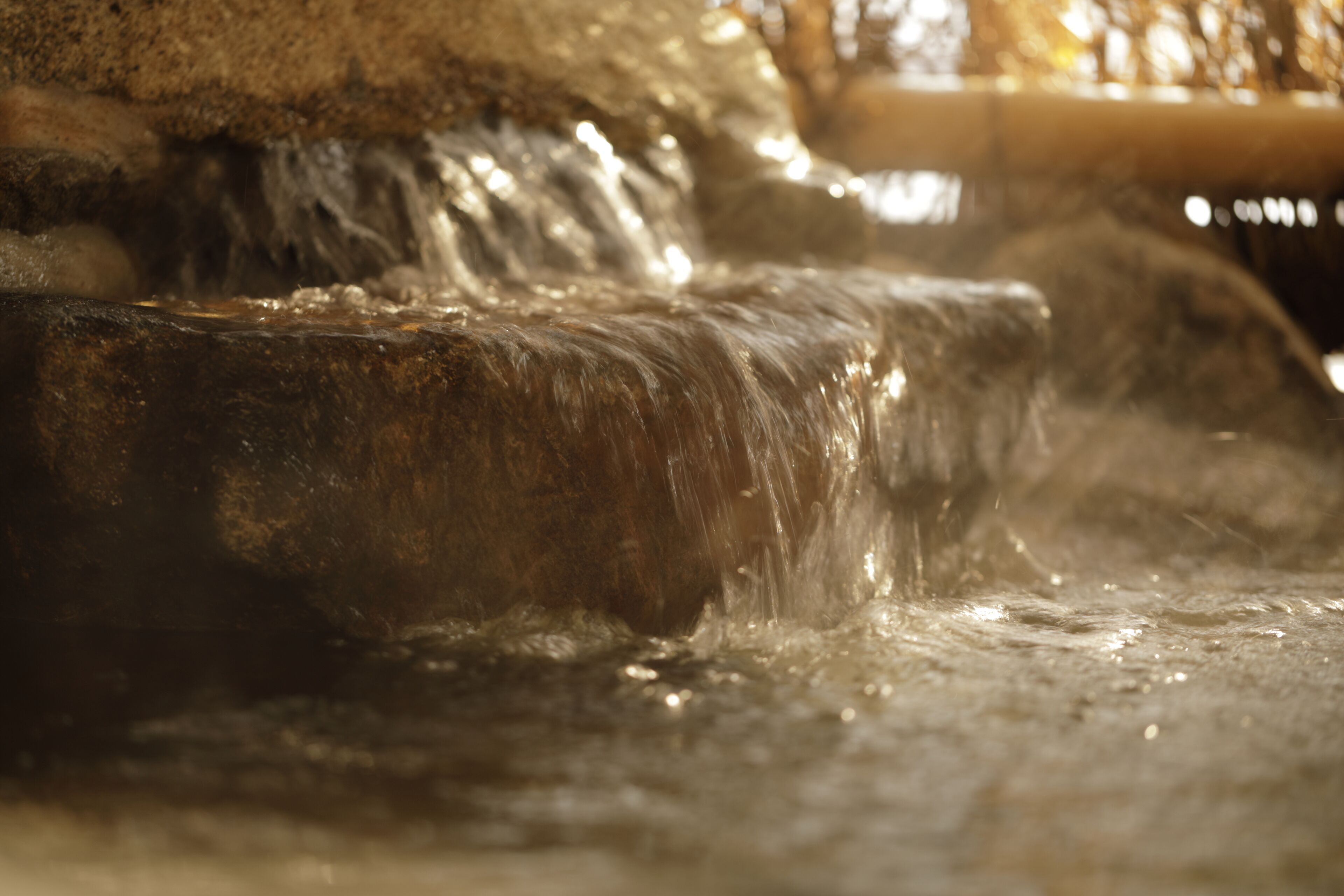 A close-up of a water feature with flowing water over rocks.