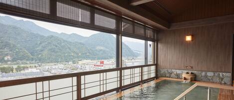 En traditionel japansk onsen med udsigt til bjerge og bybillede.