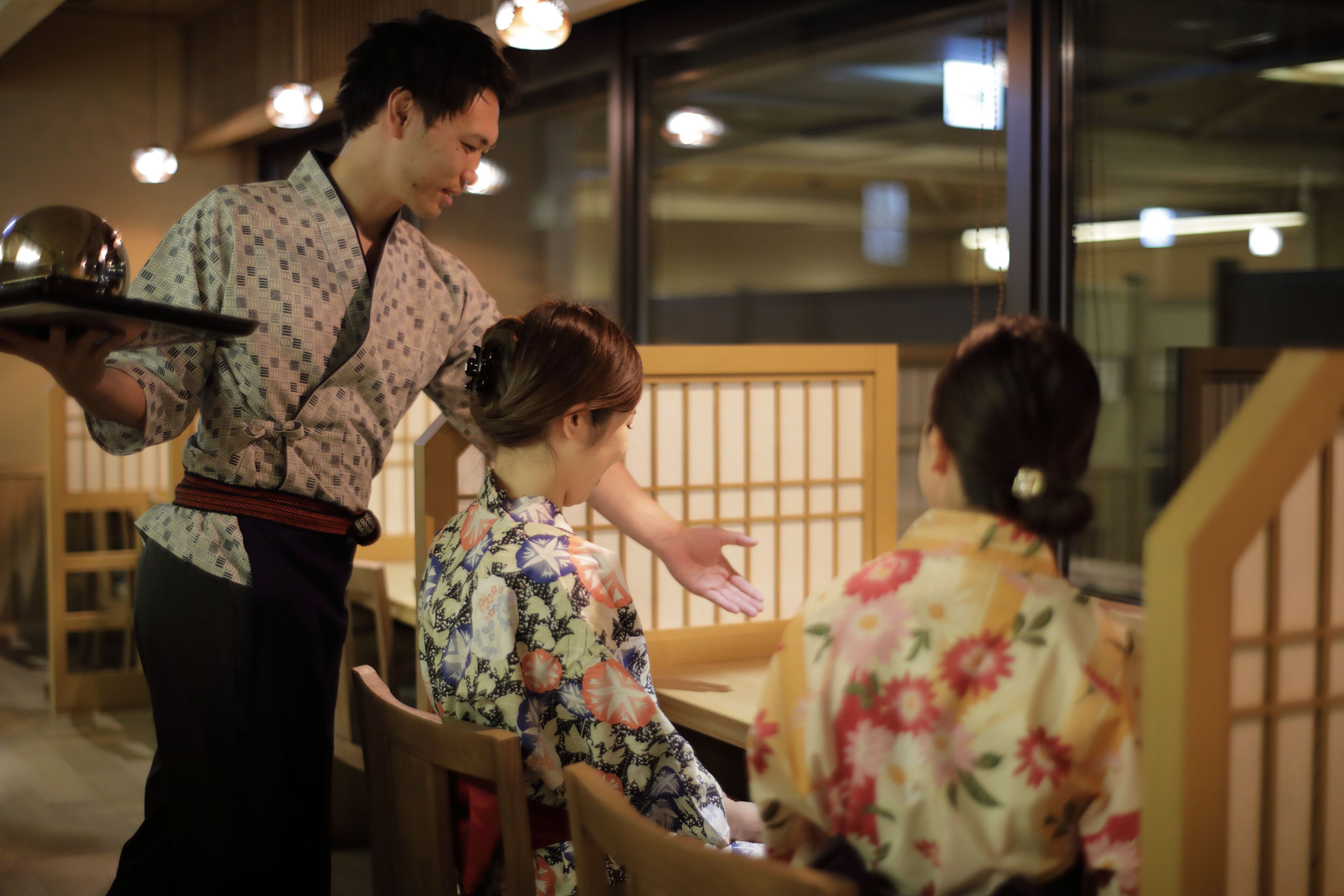 A traditional Japanese restaurant interior with wooden furniture and tatami mats.