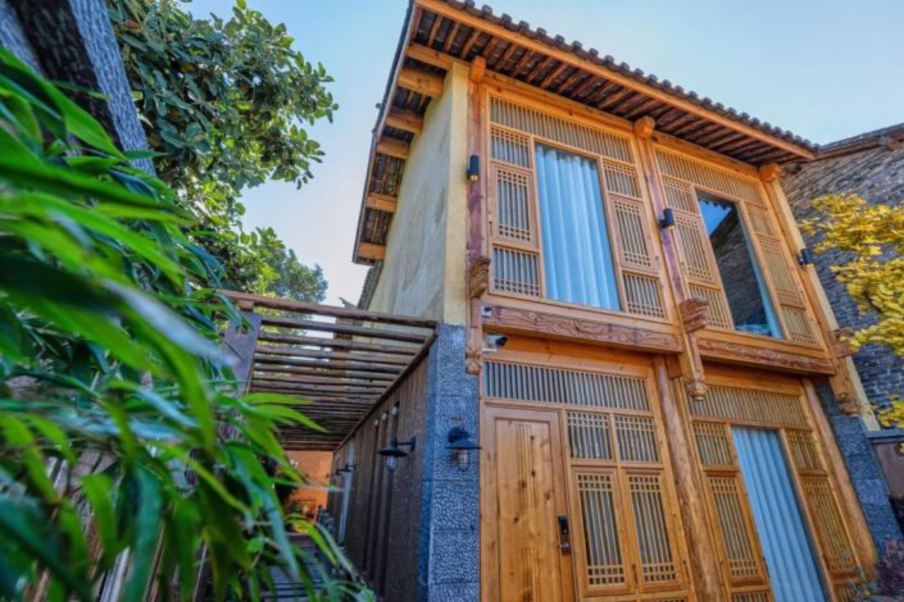 Ein traditionelles Holzgebäude mit Balkon und Steinmauer.