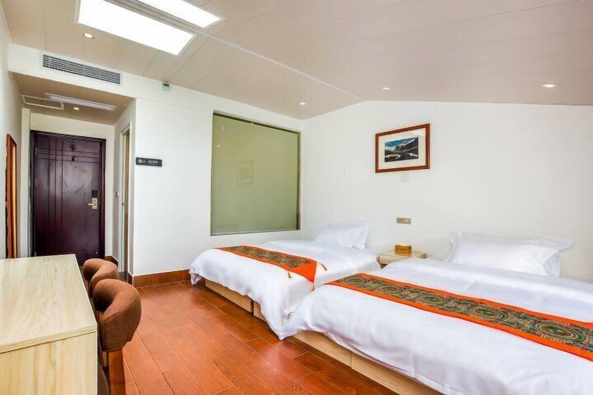 Ein Hotelzimmer mit zwei Betten, einem Schreibtisch und einem Stuhl.