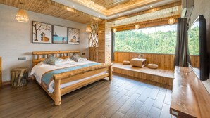 A wooden cabin with a bed, a bench, and a large window overlooking a forest. - Floral Hotel Longsheng Yueshangshanshe (Guilin)