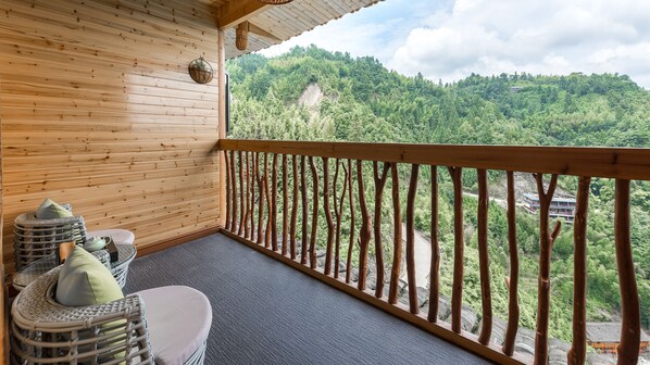 A wooden balcony with a view of a forested hillside. - Floral Hotel Longsheng Yueshangshanshe (Guilin)