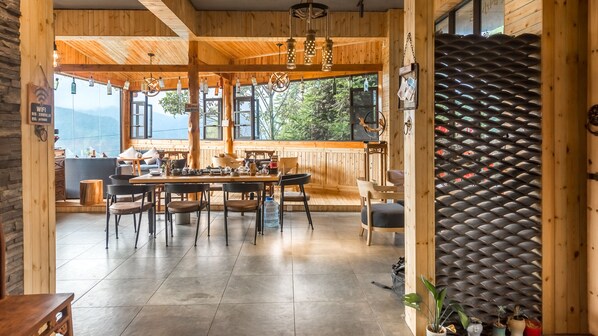 A wooden interior with a dining area, a large window, and a 'Welcome' sign. - Floral Hotel Longsheng Yueshangshanshe (Guilin)