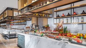 A modern kitchen with marble countertops, a variety of food items, and neatly organized shelves with kitchenware. - Projoy Hotel Tianfu Chengdu (Chengdu)