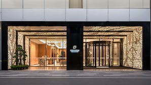 A hotel entrance with a modern design, featuring a glass door, a turnstile, and a sign with the hotel name. - Projoy Hotel Tianfu Chengdu (Chengdu)