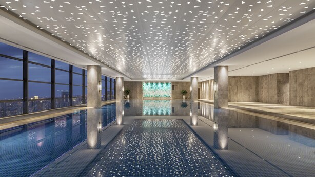 A modern indoor swimming pool with a city view, a ceiling with geometric light fixtures, and a reflective floor. - Projoy Hotel Tianfu Chengdu (Chengdu)