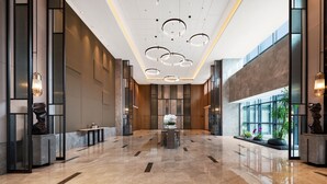 A spacious lobby with a polished marble floor, modern lighting fixtures, and a central seating area. - Projoy Hotel Tianfu Chengdu (Chengdu)