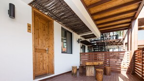 Une porte en bois avec une poignée en métal, un banc en bois et une petite table avec des tabourets.