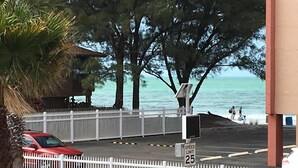 Ein Parkplatz mit Geschwindigkeitsbegrenzung auf 25, einem weißen Zaun und Blick auf das Meer.