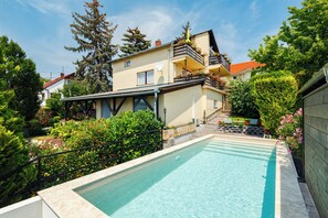 A residential building with a swimming pool, surrounded by lush greenery and a well-maintained garden. - Casa Montana-Mokka Apartment (Balatonalmadi)