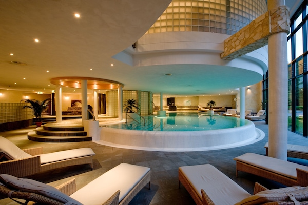 Una piscina techada, sillones reclinables de piscina