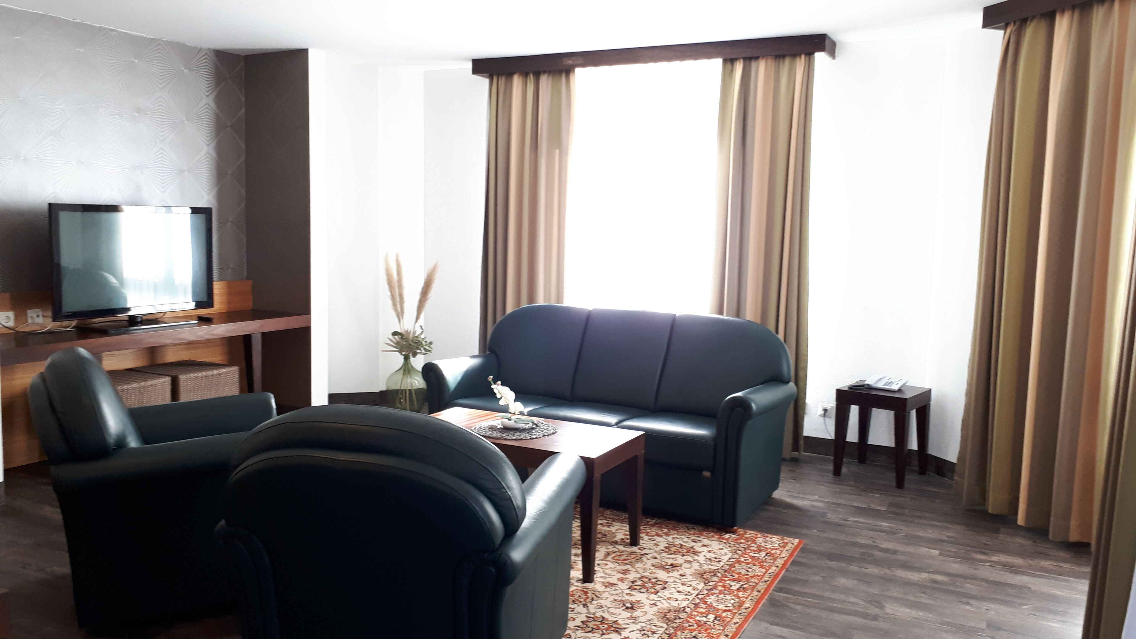 Una sala de estar moderna con un sofá, una mesa de centro, un televisor y una mesita auxiliar.