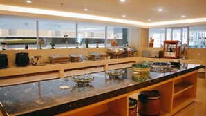A modern kitchen with a marble countertop, various appliances, and a large window offering a view of the city. - Shanshui Trends Hotel Pingtan Branch (Fuzhou)