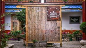 A traditional bamboo gate with a sign that reads "Moet U". - Floral Hotel Libo Meet Inn (Qiannan)