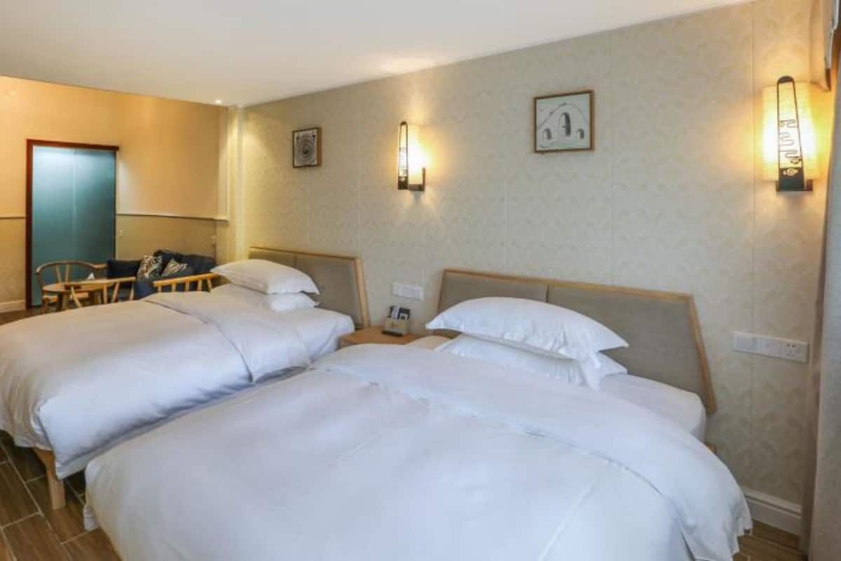 Una habitación de hotel con dos camas individuales, un escritorio y una silla.