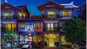 A traditional building with multiple balconies and a sign indicating it is a hotel. - Floral Hotel Libo Meet Inn (Qiannan)