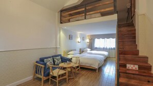 A bedroom with a double bed, a small sofa, a chair, and a wooden staircase. - Floral Hotel Libo Meet Inn (Qiannan)
