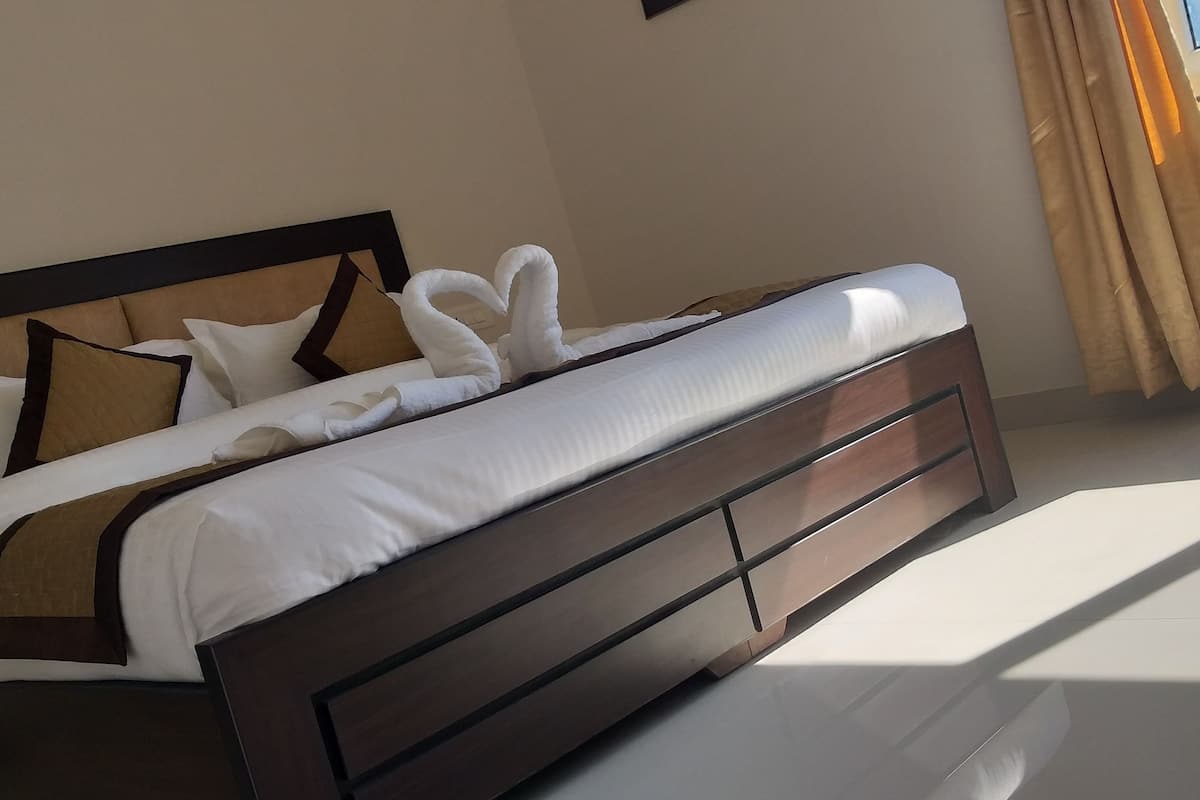 A neatly made bed with a wooden headboard, white bedding, and decorative pillows.