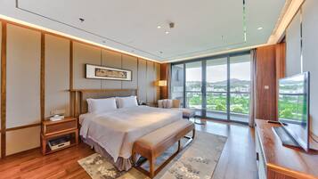 Un dormitorio moderno con una cama grande, un televisor y vistas a la ciudad.