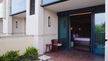A modern building with a balcony, a bed, and a chair.