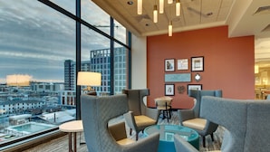 A modern lounge area with comfortable seating, a glass coffee table, and artwork on the wall. - Drury Plaza Hotel Nashville Downtown (Nashville)