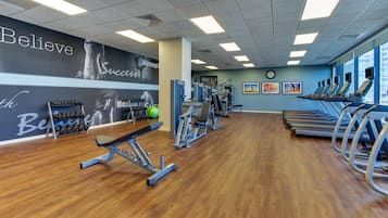 A gym with exercise equipment, treadmills, and motivational wall art.