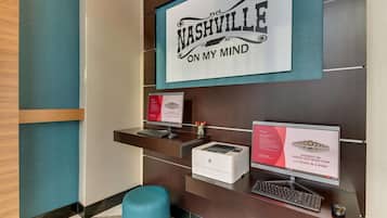 Et receptionsområde med et skilt, der står "Nashville on my mind", en stationær computer, en printer og et lille skrivebord med et tastatur og mus.