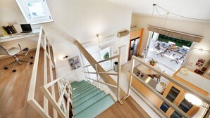 Un appartement à plusieurs niveaux, comprenant un escalier, un coin repas et une cuisine.