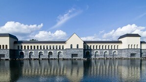 A large building with a central triangular section and multiple arched windows along the sides. - Yukkura Inn (Aizuwakamatsu)