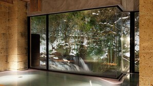 A modern interior with a large glass window reflecting a forest scene. - Yukkura Inn (Aizuwakamatsu)