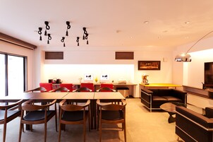 Una cocina moderna con comedor, que incluye una mesa larga, sillas y un horno empotrado.