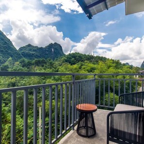 A balcony with a view of lush green mountains and a clear sky. - Floral Hotel Yangshuo Xiaozhuxiangxie (Guilin)