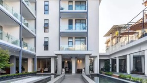 Un bâtiment moderne doté d’une cour intérieure, de nombreux balcons et d’une façade en verre.