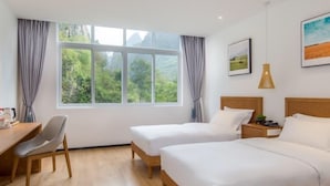 A hotel room with two single beds, a desk, a chair, and a large window with curtains. - Floral Hotel Yangshuo Xiatangzhai (Guilin)