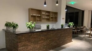 A modern kitchen with a brick island, pendant lights, and a built-in shelf above. - Floral Hotel Yangshuo Xiatangzhai (Guilin)