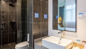 A modern bathroom with a walk-in shower, a toilet, a large mirror, and a sink. - Floral Hotel Yangshuo Xiatangzhai (Guilin)