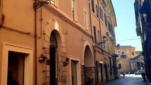 Una estrecha calle adoquinada flanqueada por edificios históricos con arcos y balcones.