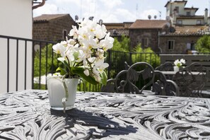 Una orquídea en maceta sobre una mesa con detalles metálicos elaborados.