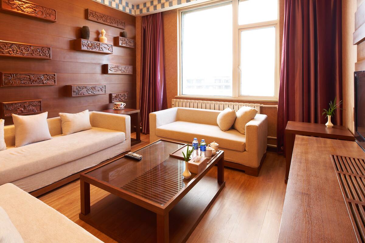 A spacious living room with two sofas, a coffee table, and decorative wall panels.